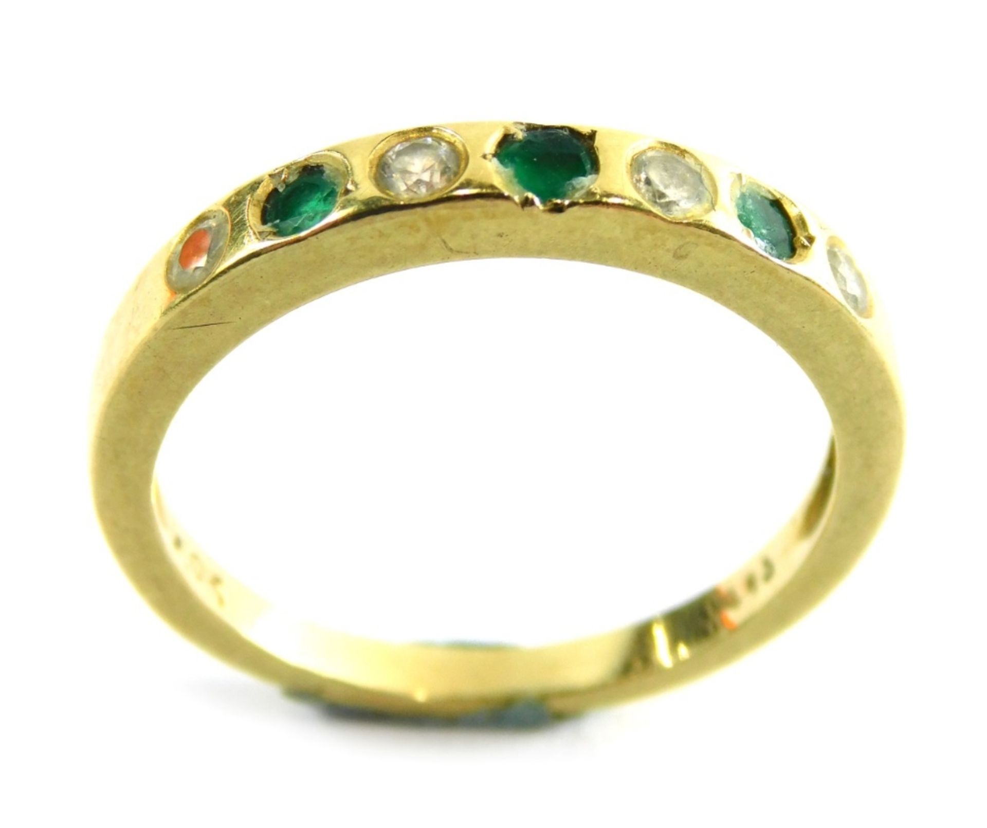 An emerald and diamond half hoop dress ring, set with three emeralds and four diamonds, each in an i