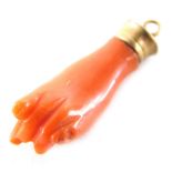 A coral fist pendant, formed as a hand forming fist, lacking forefinger, in a yellow metal pendant m