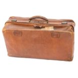 A 20thC brown leather Gladstone bag, with articulated centre, and part luggage labels, 38cm high, 57