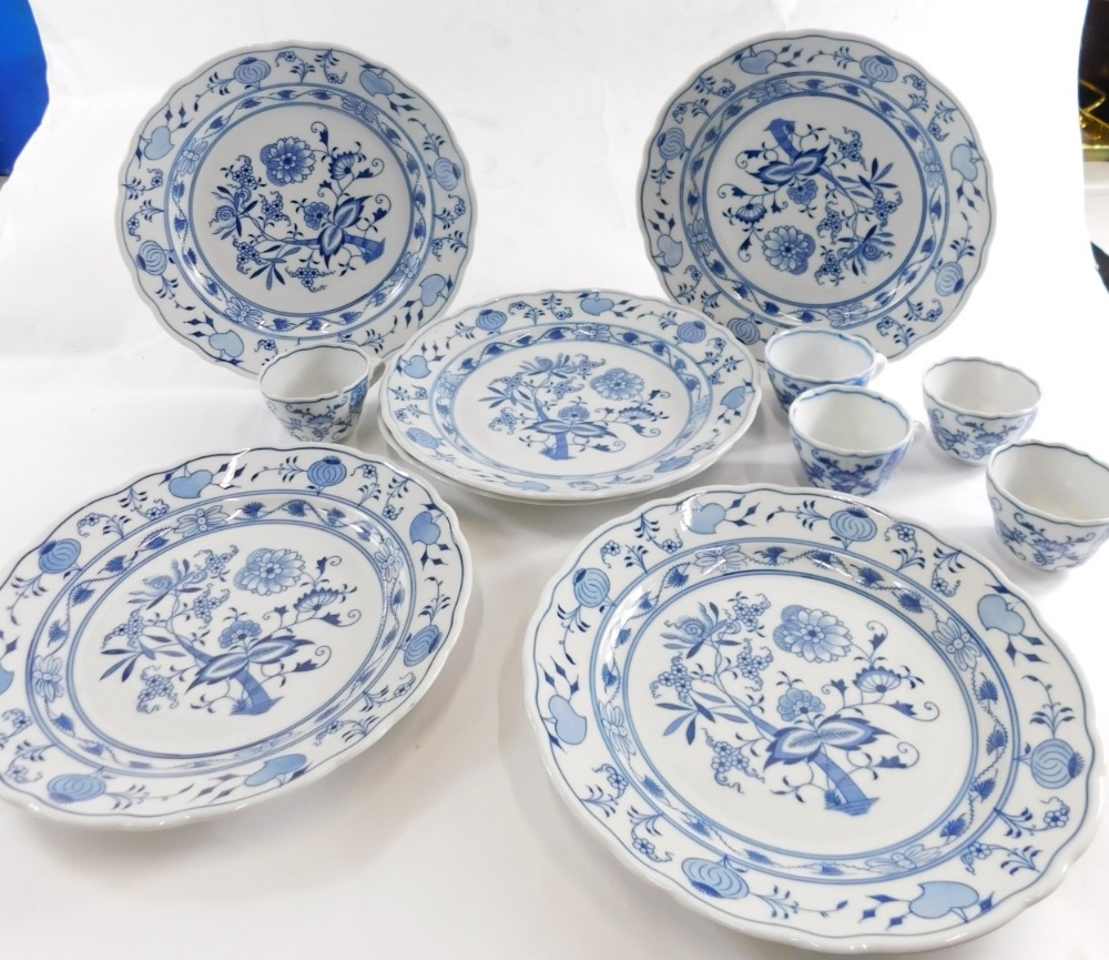 A Meissen blue and white part service, onion plate, cups, plates 23cm wide decorated with flowers, b