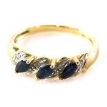 A 9ct gold dress ring, set with eight illusion set tiny diamonds and three marquise shaped blue/gree