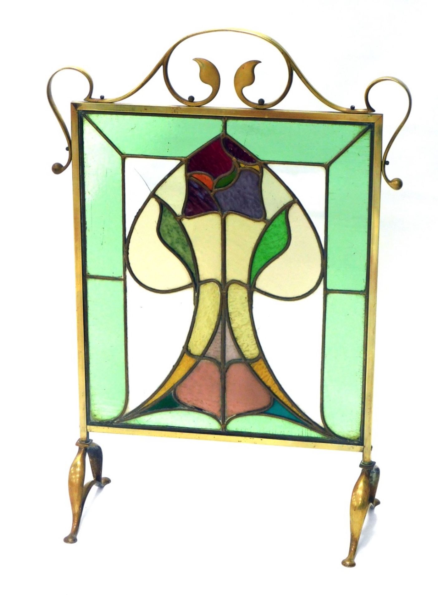 An early 20thC brass Art Nouveau fire screen, with lotus flower coloured glass centre, and scroll ou