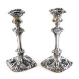 A harlequin pair of William IV candlesticks, by Henry Wilkinson & Co, each repousse decorated with l