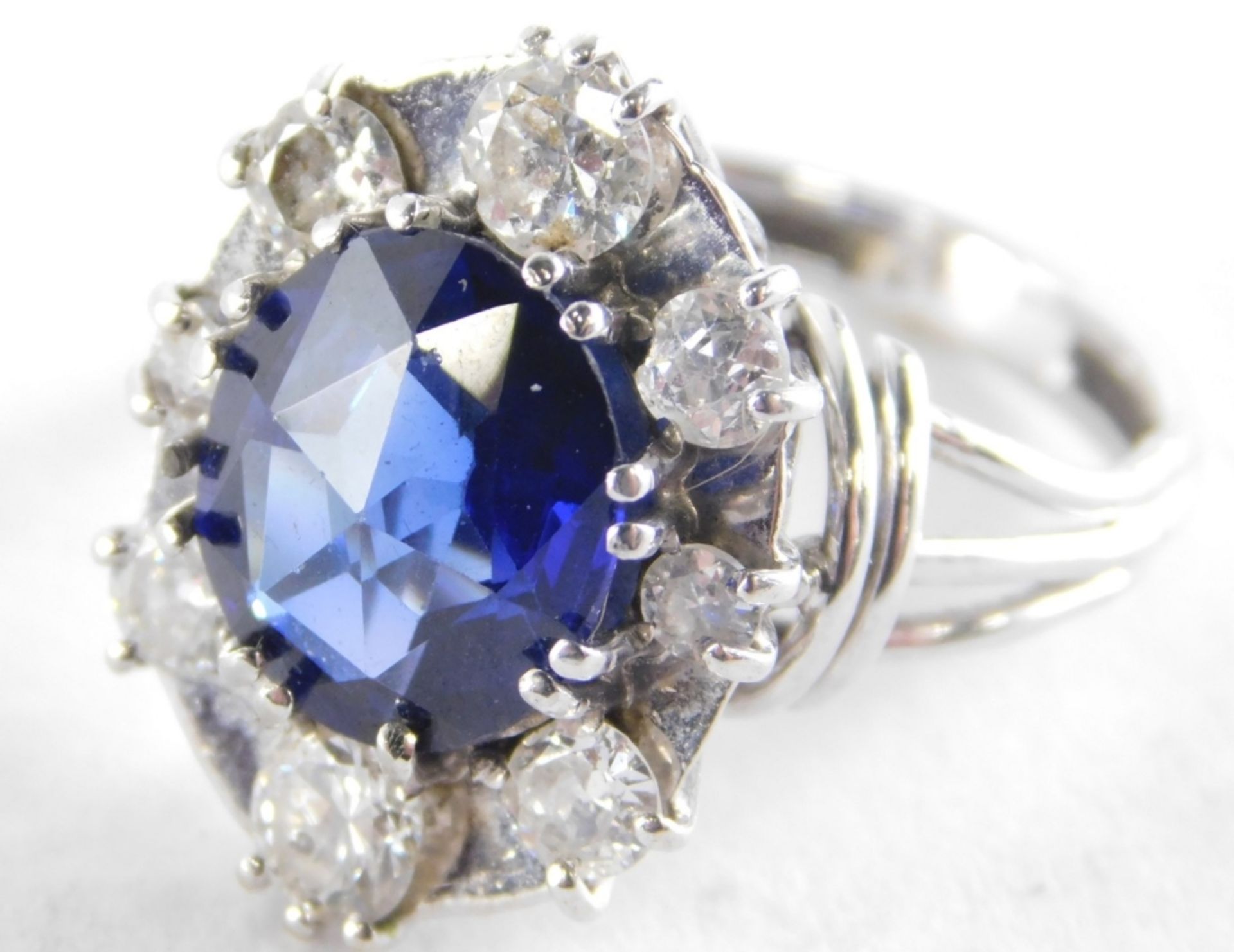 A synthetic sapphire and diamond set dress ring, the oval cut synthetic sapphire 11.4mm x 9.6mm x 5. - Image 2 of 2