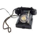 A 20thC black Bakelite telephone, with front drawer, cord attached receiver and chrome plated articu