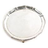 A George V silver salver, by Atkin Brothers, with piecrust edge on triple feet, marked Presented to