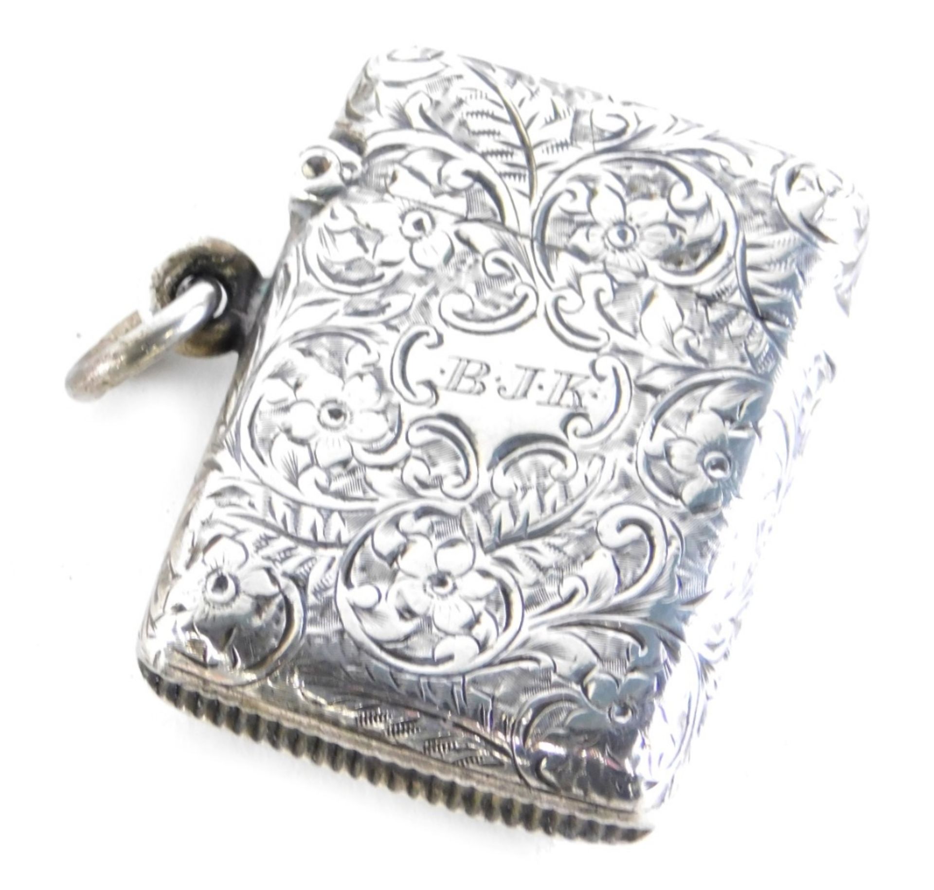 An Edward VII silver Vesta case, decorated with scrolls and flowers, with plain ring side, match str