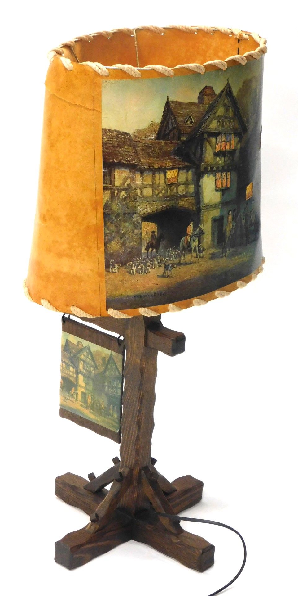 An oak table lamp, with leather shade transfer printed with tavern scene marked Bennet, on a carved