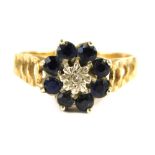 A 9ct gold dress ring, with floral cluster set with central tiny diamond in illusion setting, surrou