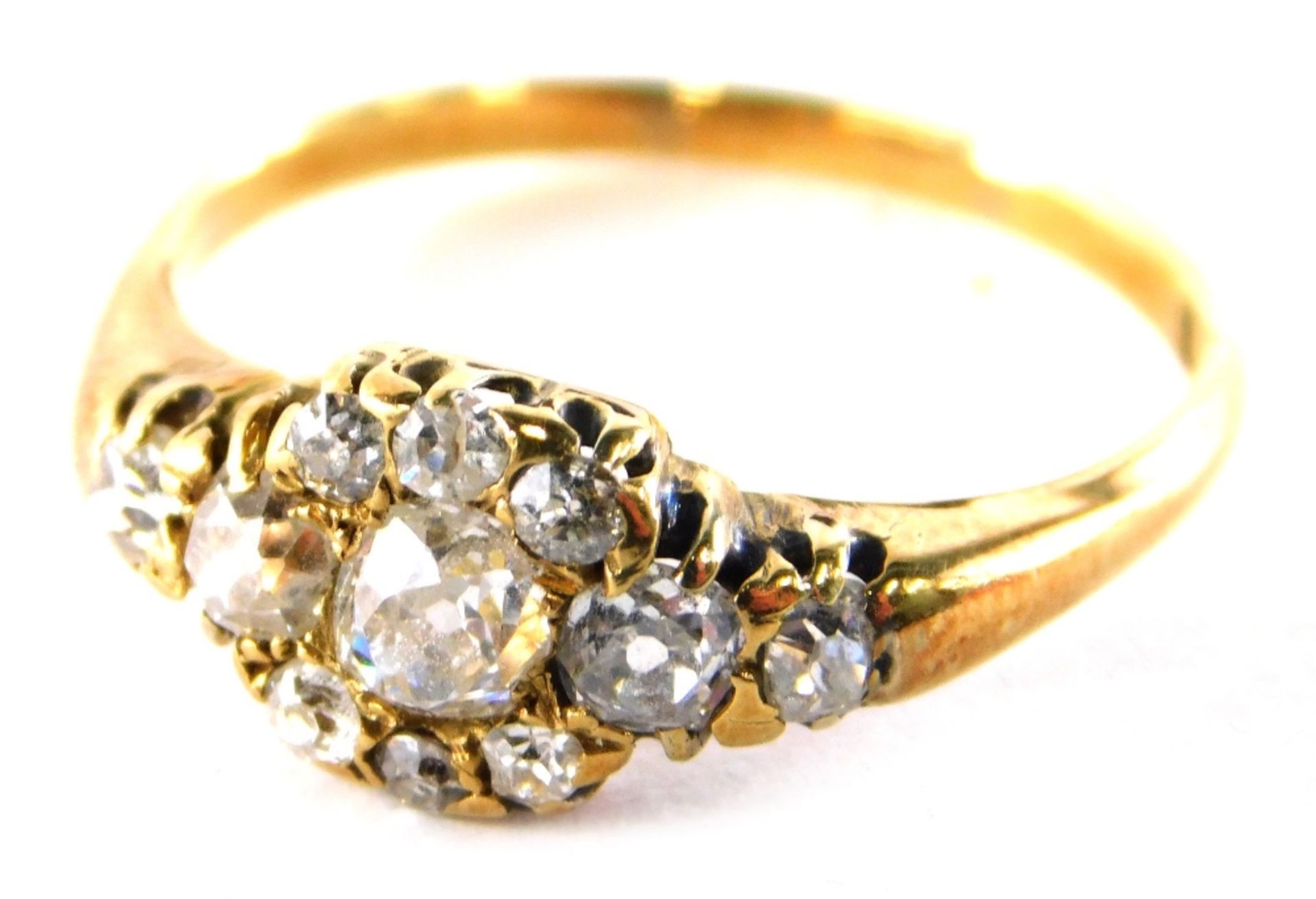 An Edwardian diamond set dress ring, set with old cut diamonds, with central floral cluster the larg