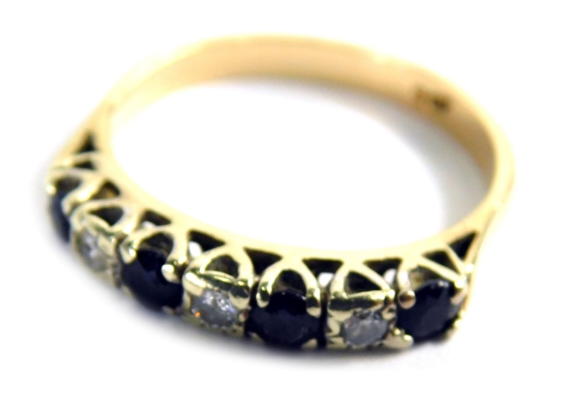 A sapphire and diamond half hoop dress ring, set with four round brilliant cut sapphires and three r