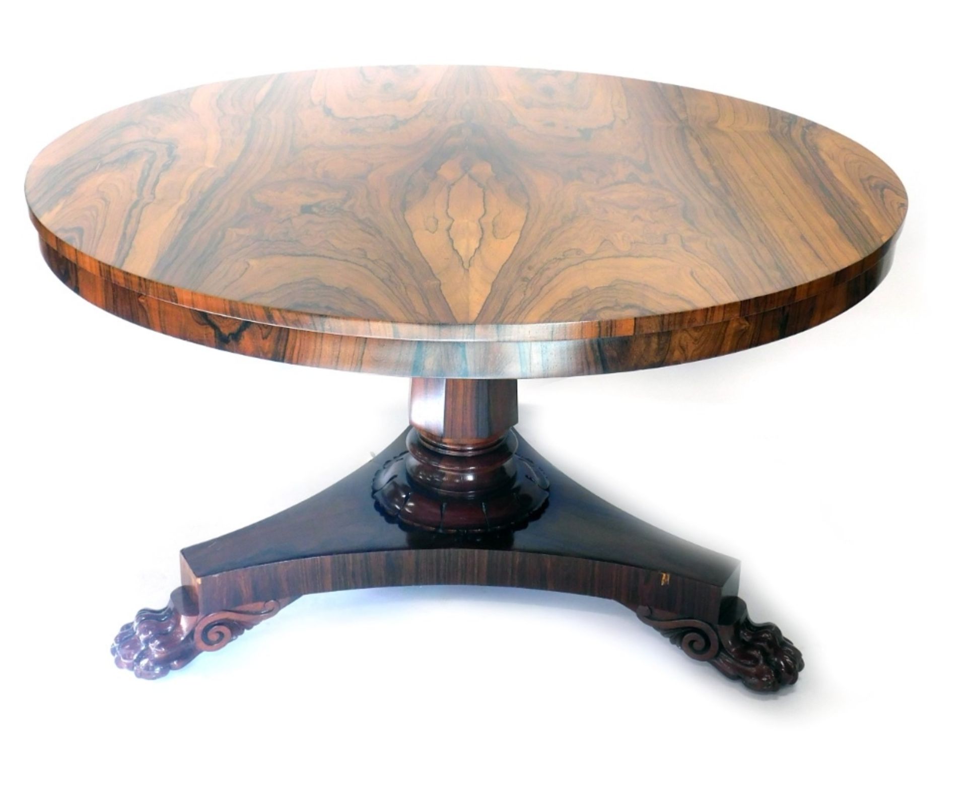 A William IV rosewood tilt top dining table, the circular top on a heavy stem, terminating in platfo