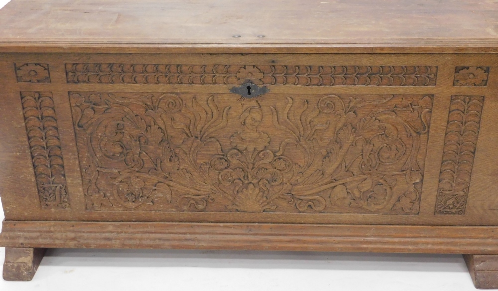 A heavily carved 19thC French oak coffer, the rectangular top revealing a plain interior, above a he - Image 2 of 3