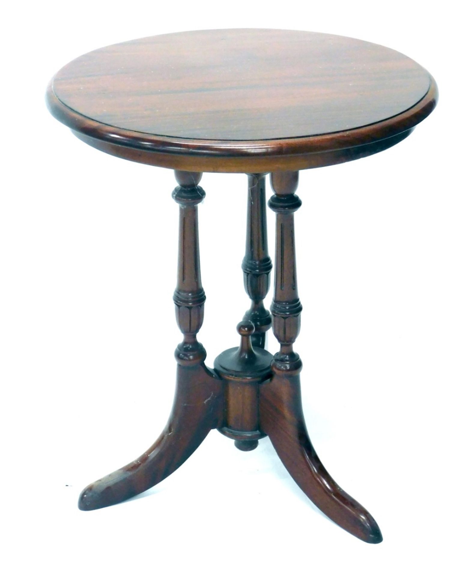 A mahogany occasional table, the circular top on triple turned supports terminating in sabre legs, 6