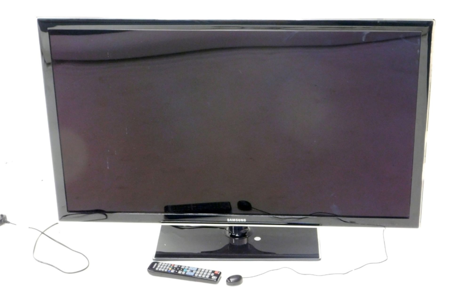 A Samsung UE46D5320 42" flat screen television, on stand, with remote control and wire.