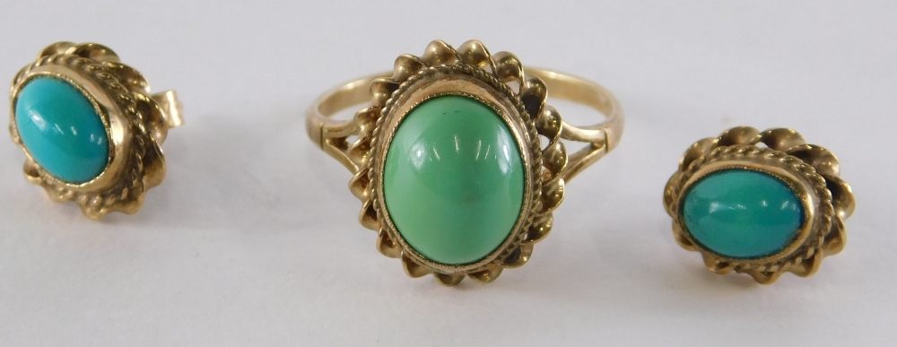 A 9ct gold turquoise dress ring, the cabochon set turquoise in a raised rub over setting, with rope