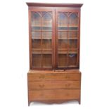 A 19thC library bookcase of large proportion, the fixed cornice raised above a pair of glazed doors