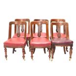 A set of four Victorian mahogany spoon back dining chairs, each with a solid splat and red upholster