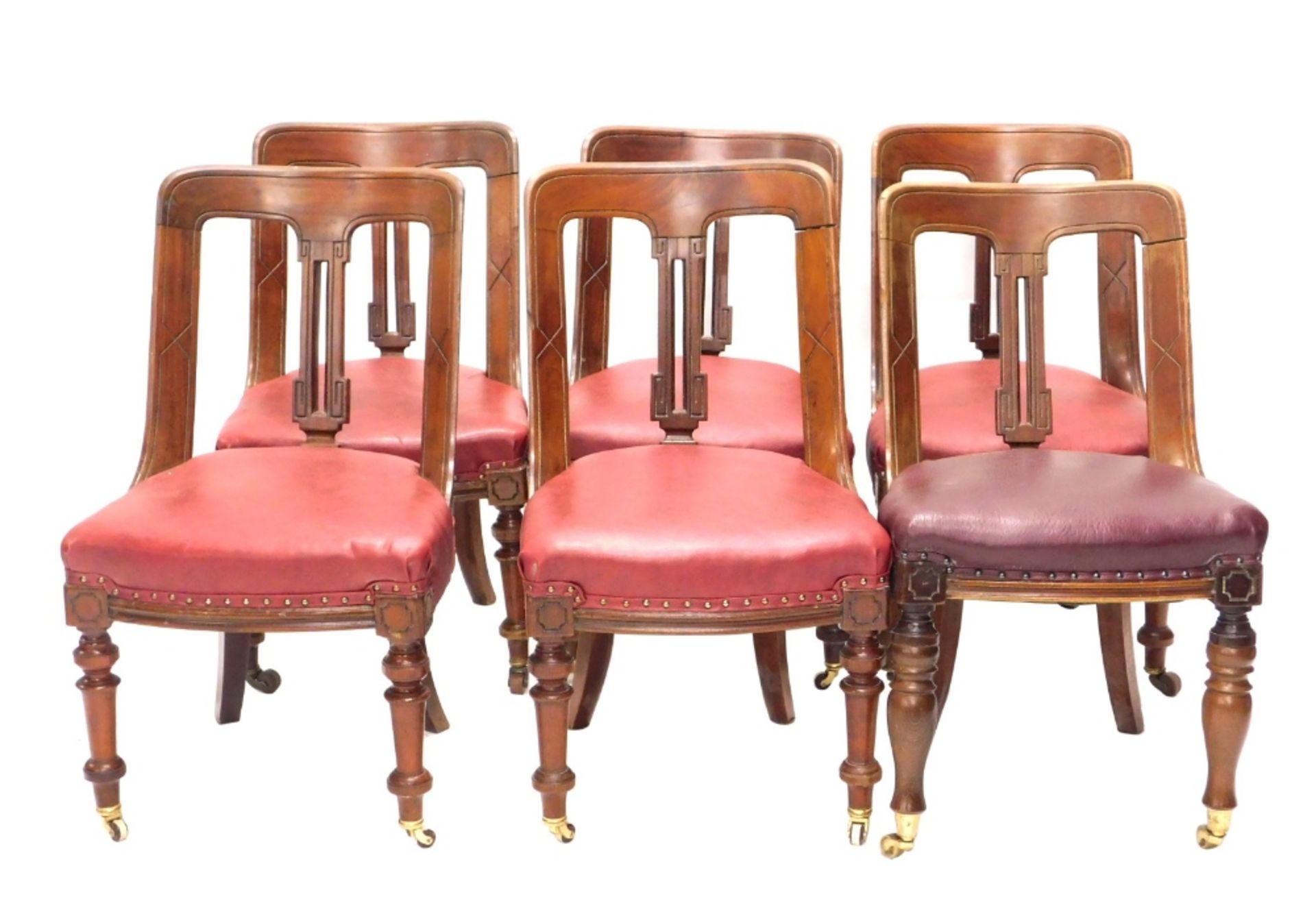 A set of four Victorian mahogany spoon back dining chairs, each with a solid splat and red upholster