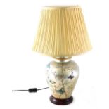 An urn table lamp, the semi porcelain urn body decorated with butterflies and flowers on a silver gr