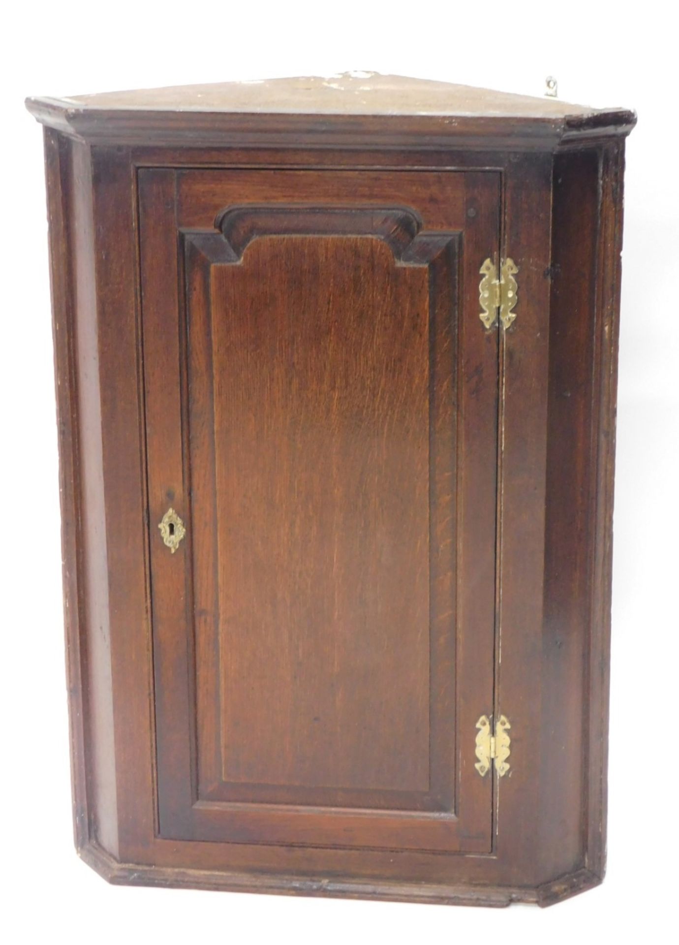 A late 18thC oak hanging corner cabinet, the panelled door revealing a fitted interior, with two she