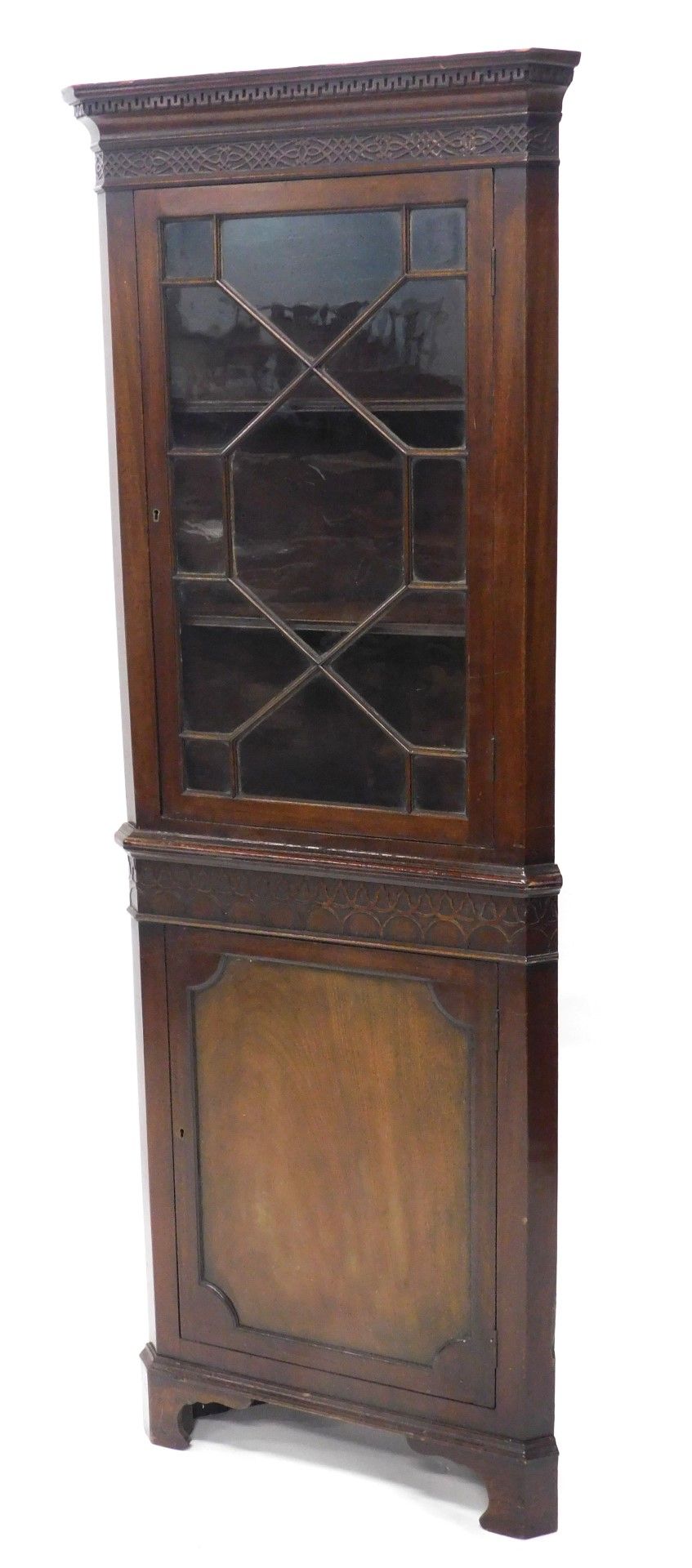 A mahogany freestanding corner cabinet, the dentil top with a blind fret, above an astragal glazed d