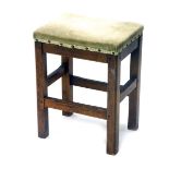 An early 20thC oak stool, overstuffed in later green material, on chamfered legs with block stretche