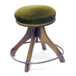 An oak framed stool, with metal hoop foot supports, overstuffed in green material, 44cm high, the to