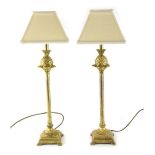 A pair of gilt metal table lamps, with pineapple and fluted stems terminating in step bracket feet w