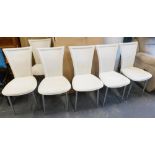 A set of six cream dining chairs.