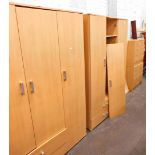 A two door lightwood finish wardrobe, and two chests of four long drawers.