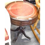 A mahogany finish drum table, with tooled leather top.