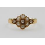 An 18ct gold diamond and pearl flower head ring, set with six pearls and three diamonds, size N, 2.7