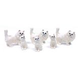 A group of Beswick pottery figures modelled as white Persian cats, comprising three standing cats, 1