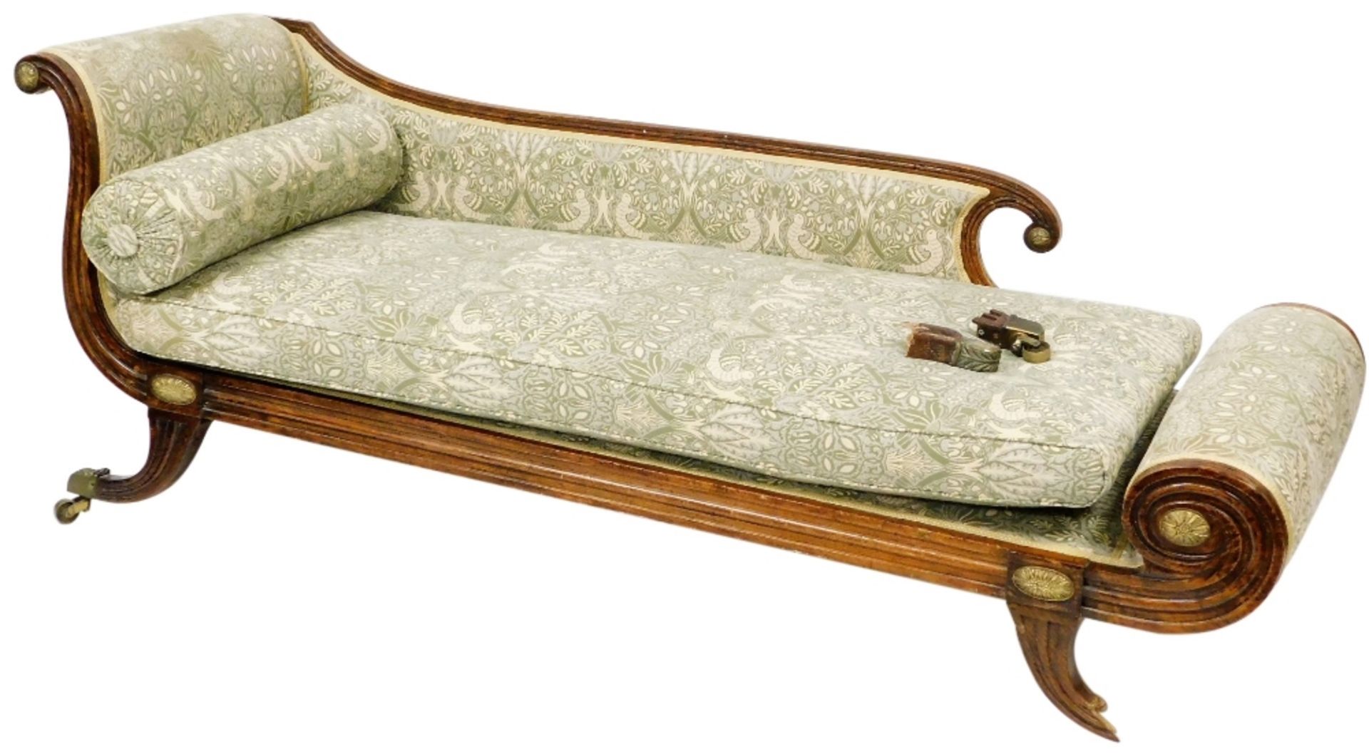 An Empire style oak framed chaise longue, upholstered in green fabric decorated with birds and flowe