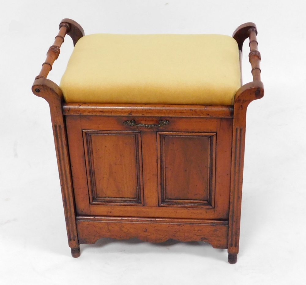 A Victorian oak piano stool, with overstuffed seat above a panelled fall, enclosing three sections f
