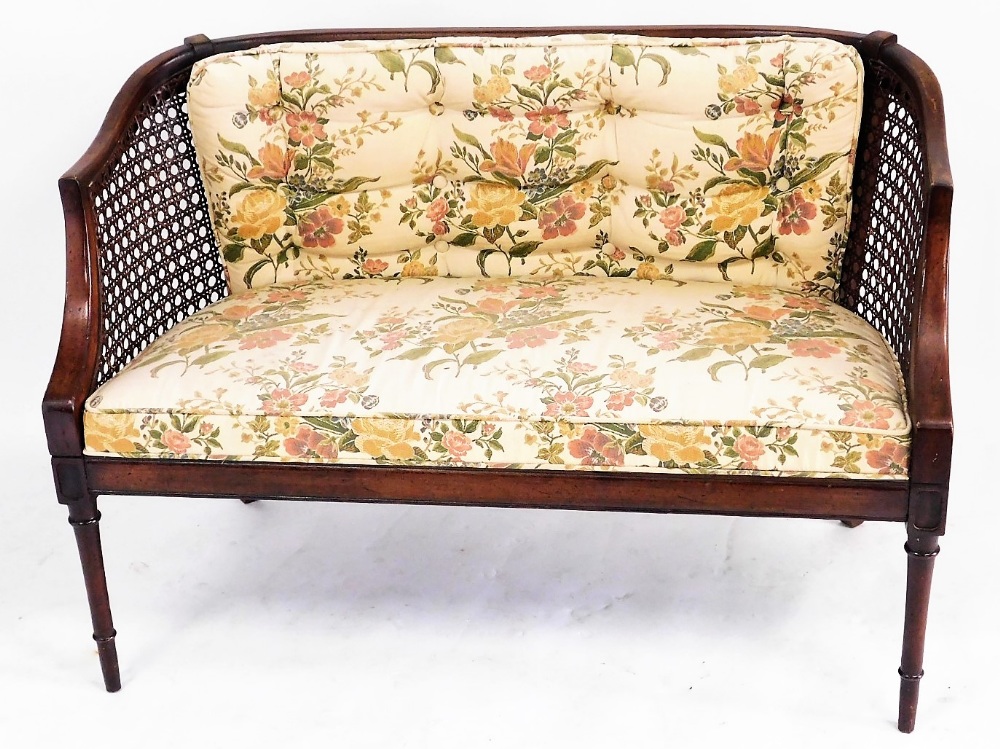 A Victorian mahogany framed bergere sofa, with caned curved back, with floral upholstered seat and b