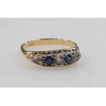A diamond and sapphire five stone ring, in an oval channelled claw setting, in yellow metal, indisti