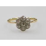 A diamond seven stone flower head ring, set in yellow and white metal, indistinctly stamped to the s