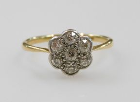 A diamond seven stone flower head ring, set in yellow and white metal, indistinctly stamped to the s