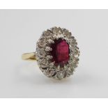 A ruby and diamond ring, the oval cut ruby and surround of diamonds, set in a white and yellow metal