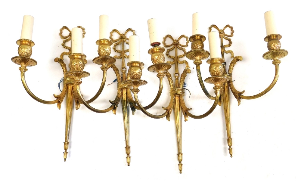 A set of four 20thC Adam style gilt metal two branch wall lights, each surmounted by a decorative bo