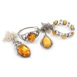 Silver and amber jewellery, comprising two pendants on chains, a bangle, and a six link bracelet on