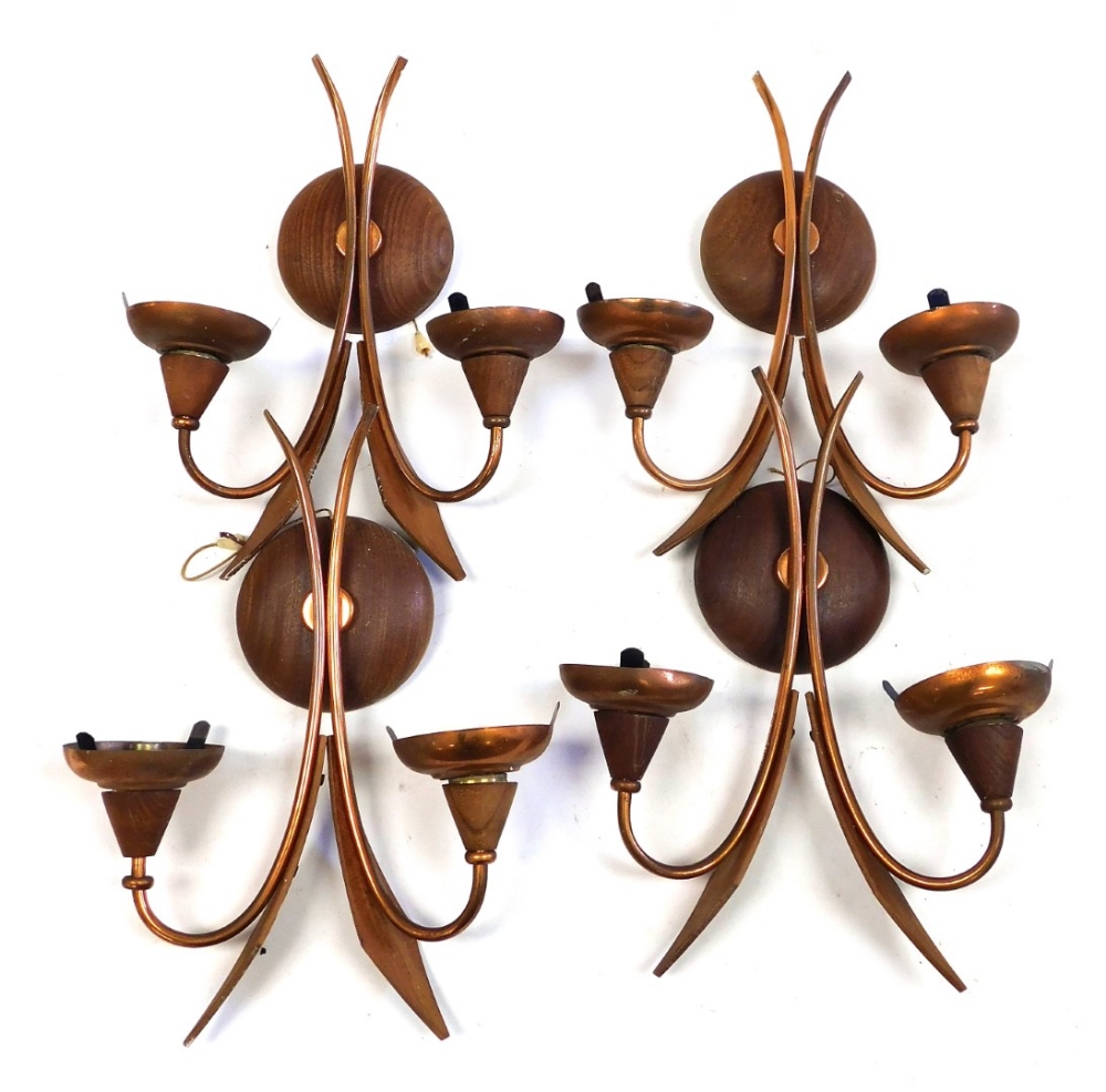 A set of four mid century teak and copper two branch wall lights, the circular wall mount surmounted