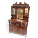 A Victorian mahogany mirror back sideboard, with a foliate carved broken neck pediment, triple bevel