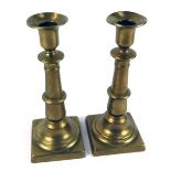 A pair of early 20thC brass candlesticks, each on square base, with turned column, 25cm high.