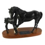 A Beswick Connoisseur model of Black Beauty and foal, on a wooden oval base, 20cm high, 28cm wide.