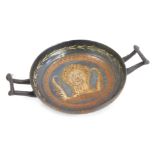 An early Roman pottery two handled bowl, decorated with a female head within a crown, and having wax