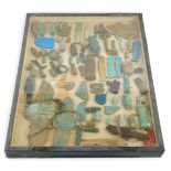 A tabletop display case containing Egyptian antiquities, including a winged scarab beetle, and beari