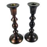 A pair of 19thC copper candlesticks, each with turned shafts, 21cm high.